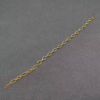 Gold and silver link bracelet with modern design on textured gray background